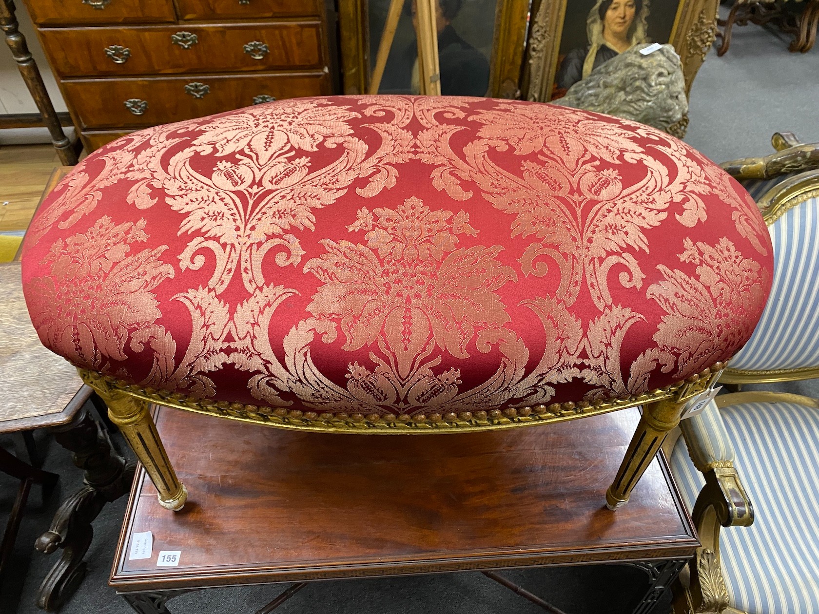 A Louis XVI style oval giltwood upholstered dressing stool, length 90cm, depth 50cm, height 50cm